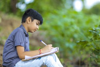 Boy writing outside